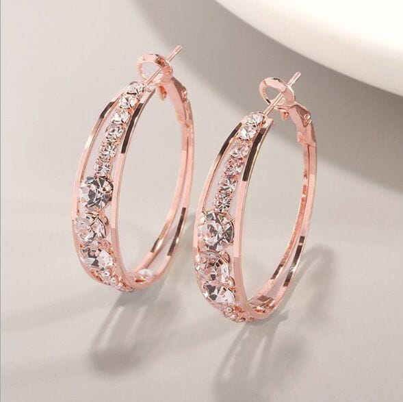 Boucles d’oreilles créoles géométriques serties de cristal pour femmes, en or rosé, ornées de cristaux transparents étincelants le long de la courbe.