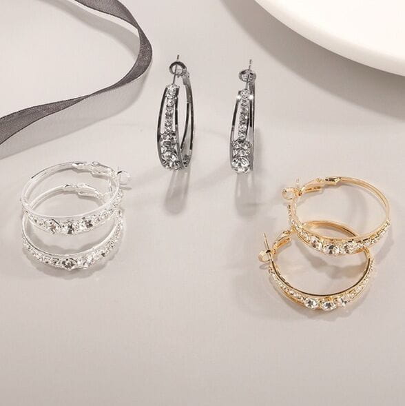 Lot de trois paires de boucles d’oreilles créoles géométriques serties de cristal pour femmes, en argent, or et noir, avec des embellissements en cristal étincelant.