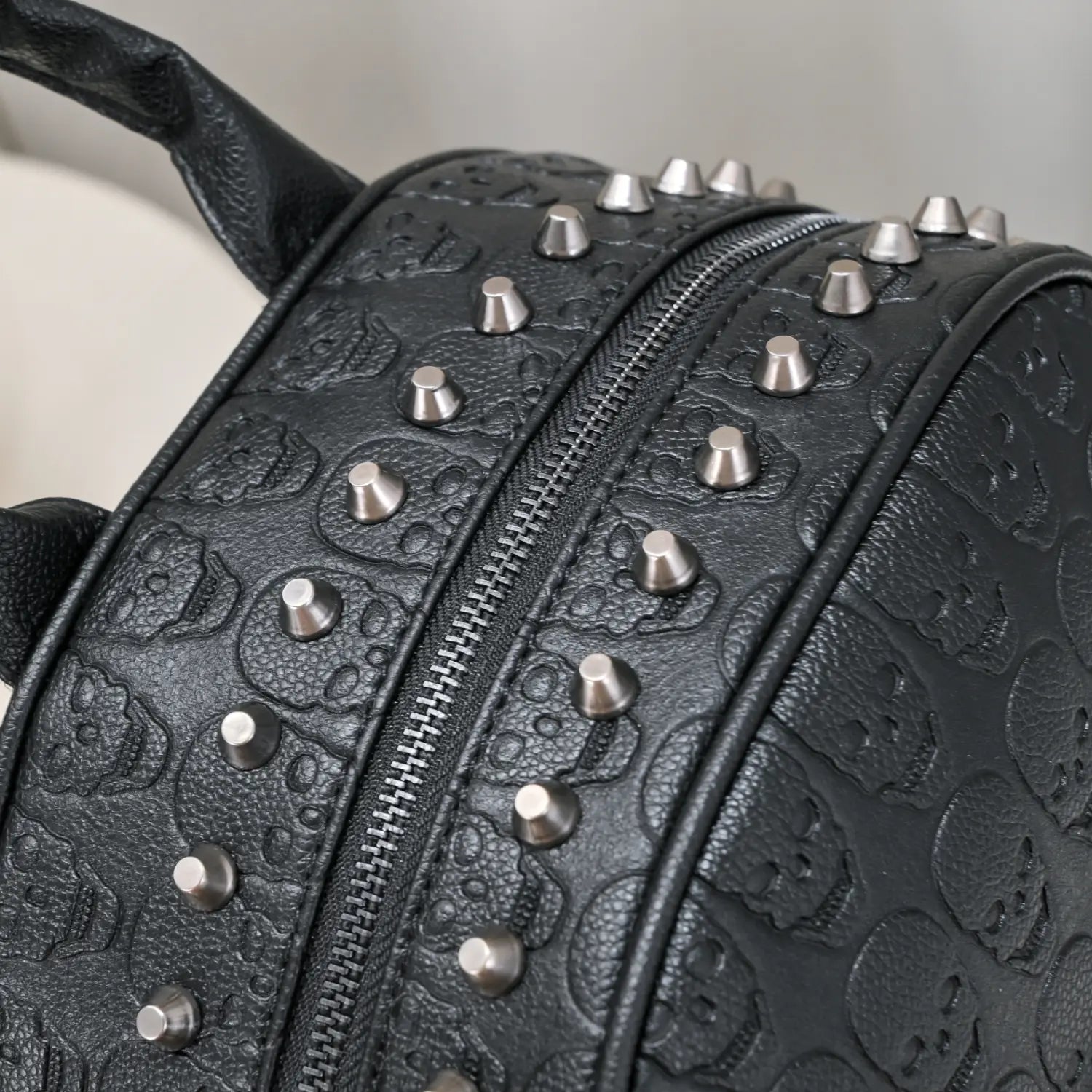 black studded skull leather commute backpack featuring silver-toned studs and embossed skull patterns on black leather for stylish daily use