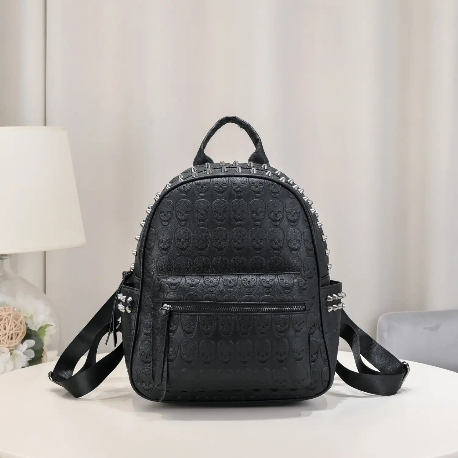 Black studded skull leather commute backpack featuring black leather material with embossed skull pattern and silver studs.