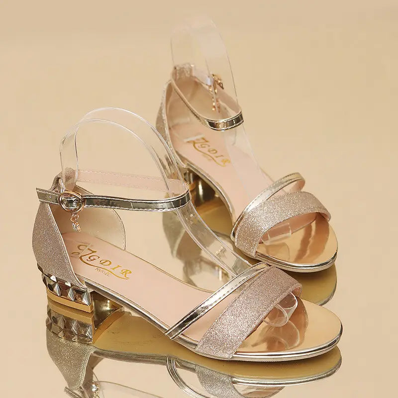 women’s glitter low heel buckle sandals featuring sparkly silver glitter with clear straps and a studded heel.