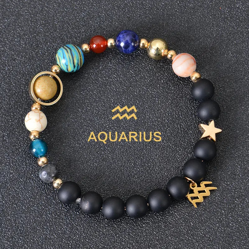 Celestial Zodiac Planet Matte Stone Beaded Bracelet featuring black matte beads, colorful blue red gold and peach gemstone-like spheres, and metallic star and Aquarius zodiac charms.