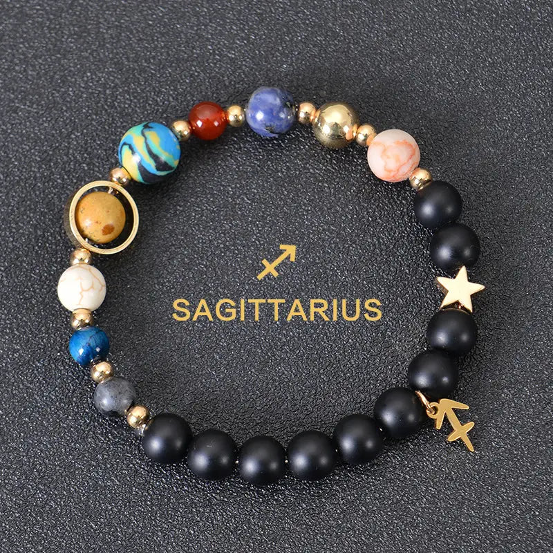 A sagittarius-themed celestial zodiac planet matte stone beaded bracelet featuring black matte beads colorful blue red and gold planet-like stones with a golden star charm.