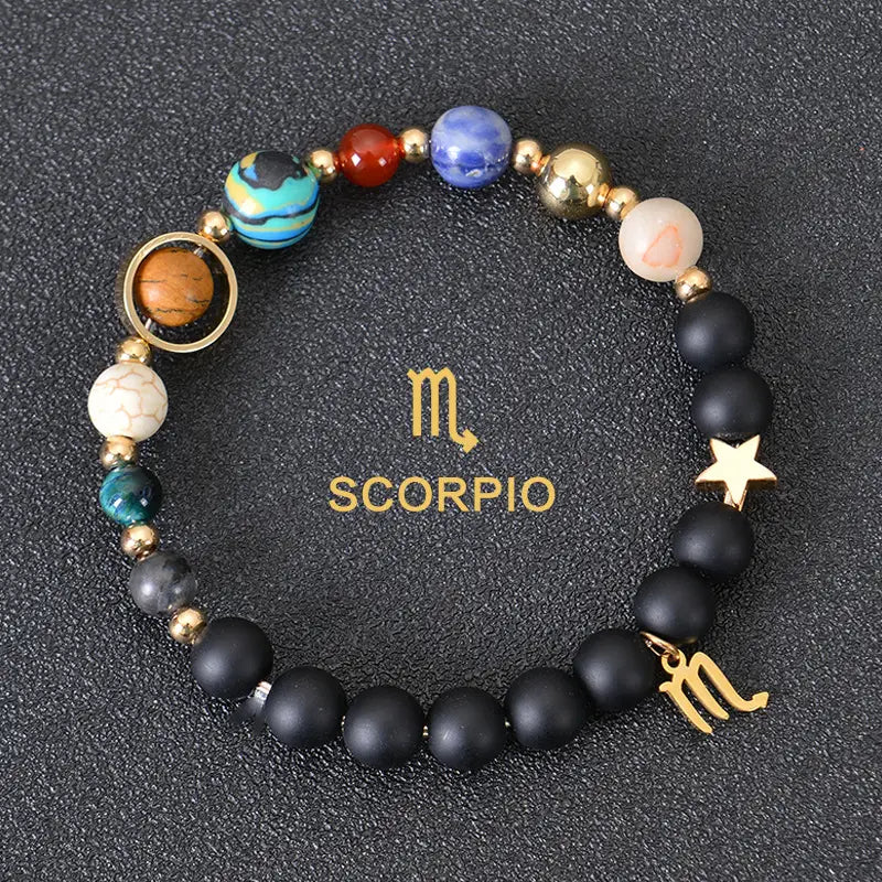 A scorpio-themed celestial zodiac planet matte stone beaded bracelet featuring black matte beads with colorful blue red and turquoise gemstone-like spheres and gold-toned metallic accents including a star charm and the zodiac symbol.