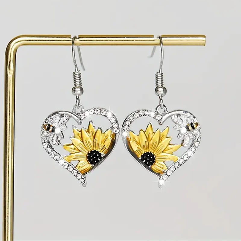 Herzförmige silberne Ohrringe mit einer leuchtend gelben Sonnenblume mit schwarzem Zentrum und klaren Strasssteinen an den Rändern aus der Kollektion der Bienen- und Sonnenblumen-Herz-Strassstein-Silberohrringe