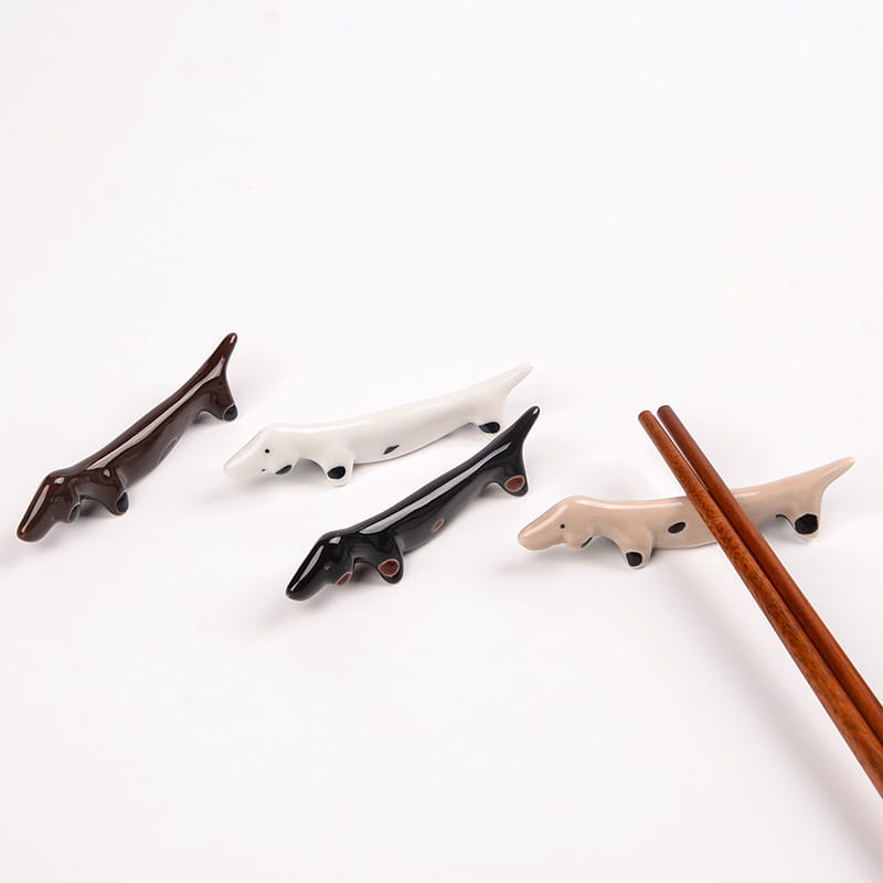 Set aus vier Dackel-Keramikstäbchenhaltern in den Glasuren Braun, Weiß, Schwarz und Beige, für die Verwendung am Tisch konzipiert
