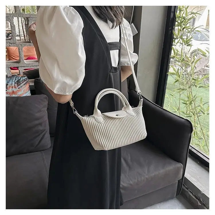 White ribbed leather longchamp le pliage pleated shoulder bag with top handle and adjustable shoulder strap minimalist pu leather tote.