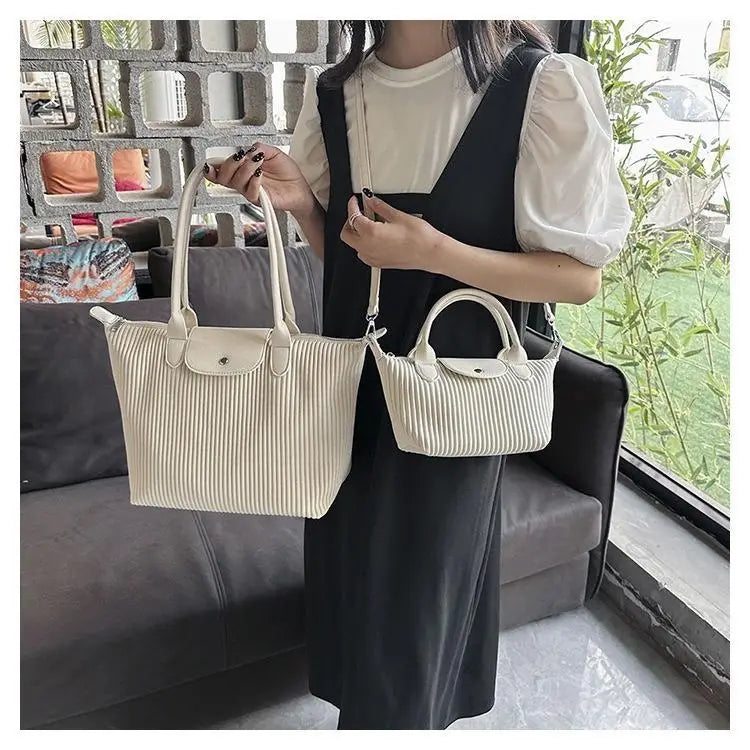Cream-colored pleated shoulder bag made of pu leather with minimalist design and silver-toned hardware tote.