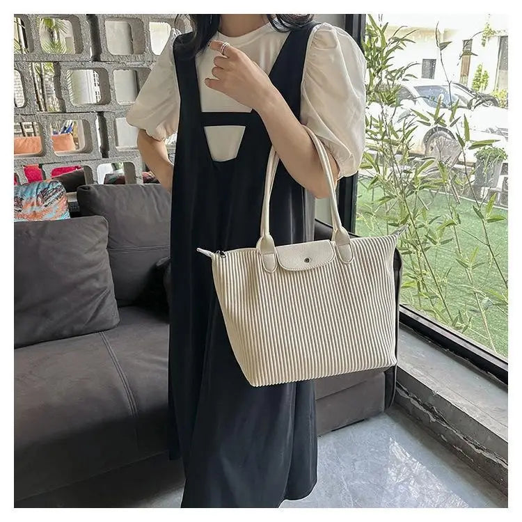 Cream-colored ribbed canvas tote bag with matching handles and flap closure from the pleated shoulder bag minimalist pu leather tote collection.