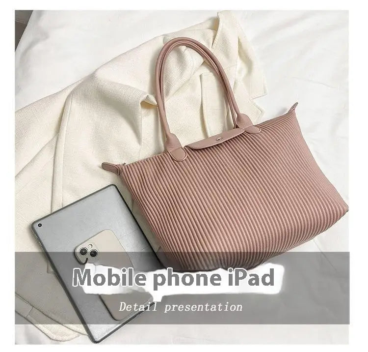 A soft pink pleated shoulder bag made of minimalist pu leather with structured handles and a tote design.