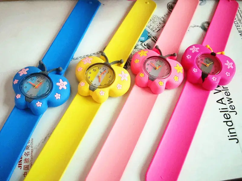 Montre-bracelet en silicone à l’effigie d’un animal en 3D, style dessin animé, pour enfants, comprenant quatre modèles colorés en forme de papillon, en bleu, jaune, rose et rose vif, avec des détails floraux sur les boîtiers en plastique.