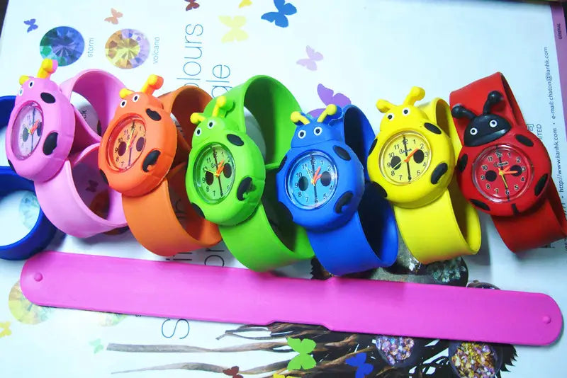 Une rangée de montres-bracelets en silicone à l’effigie d’animaux en 3D, style dessin animé, pour enfants, aux couleurs vives, avec des motifs de coccinelle en rose, orange, vert, bleu, jaune et rouge.