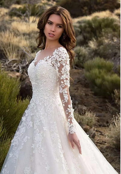A white lace off shoulder bridal wedding gown with long sleeves and a fitted bodice.