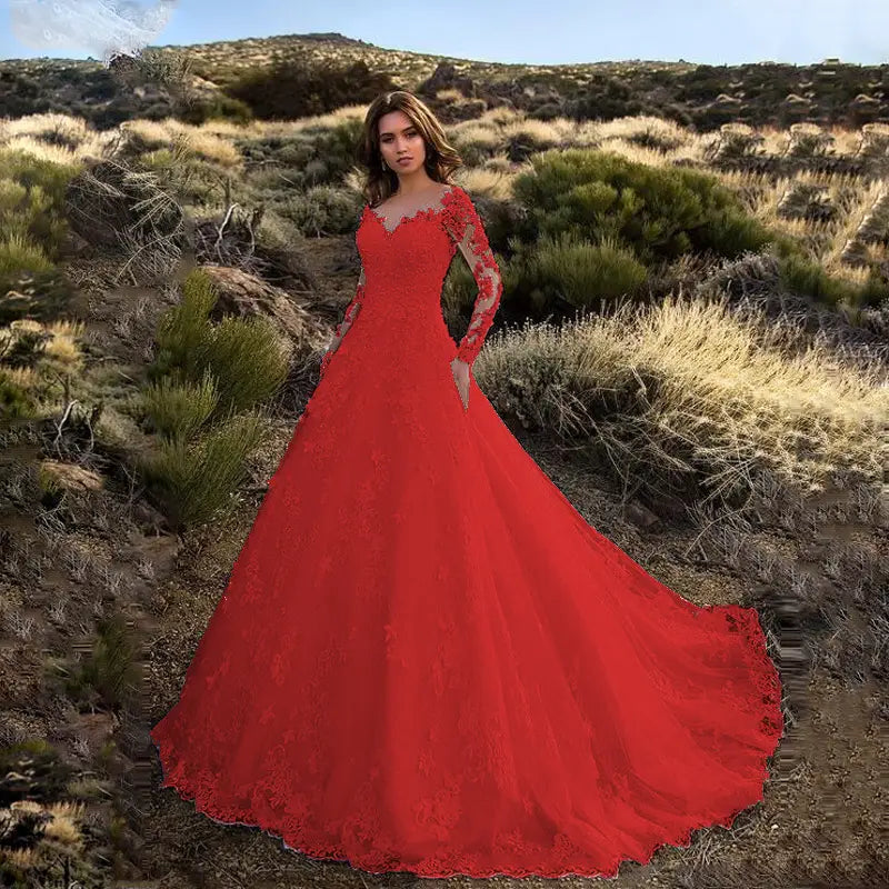 A vibrant red lace off shoulder bridal wedding gown featuring long sleeves and a flowing skirt.