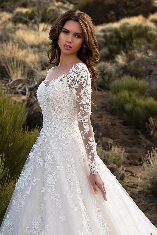 A white off shoulder lace bridal wedding gown with long sleeves and intricate floral embroidery.