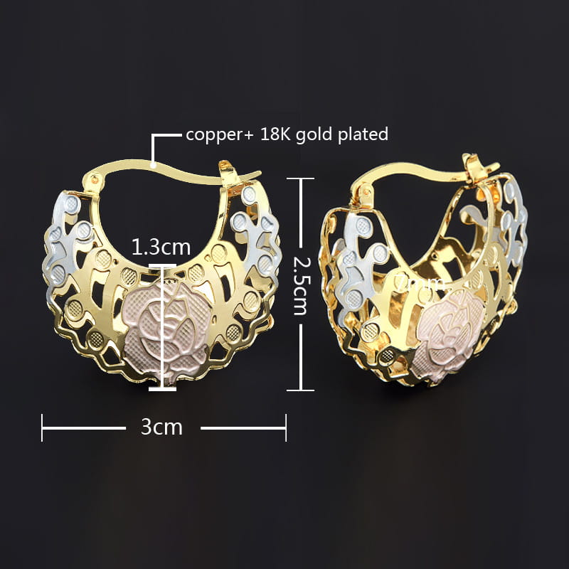 Two tone rose motif hoop earrings featuring gold and silver tones with intricate designs and pink enamel accents.
