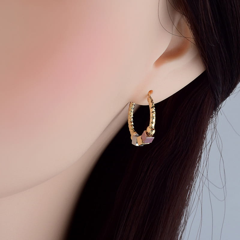 gold-toned hoop earring with twisted texture and small pink gemstone accent from two tone rose motif hoop earrings with pink enamel accents collection