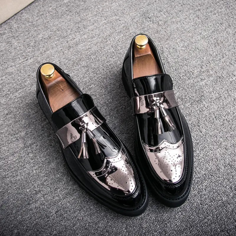 Herren-Slipper mit Lackleder, Quastenbesatz, in Schwarz und Silber, mit Brogue-Details und einem Metallschieber.