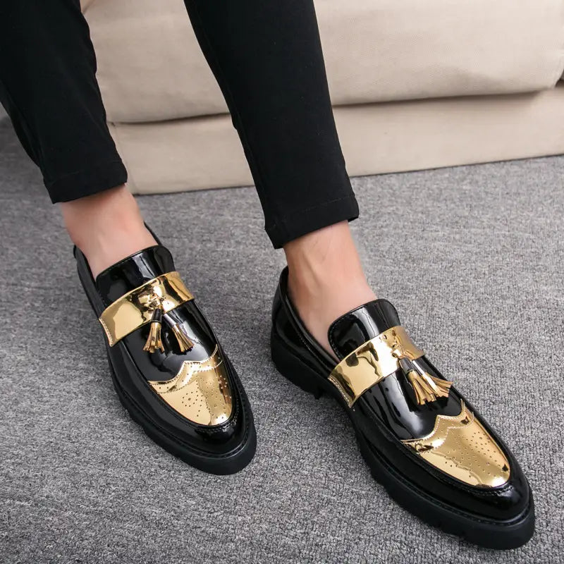 Herren-Slipper mit Lackleder und Quastenbesatz, mit glänzendem Schwarz-Gold-Zweifarben-Finish und einem Metallschieber.