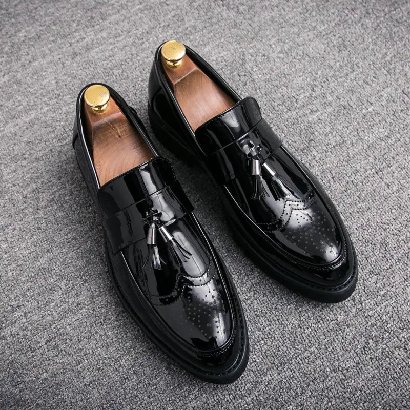 Herren-Schwarz-Slipper aus Lackleder mit Quastenbesatz, mit Brogue-Details und goldfarbenen Metall-Schuhspidern für einen gepflegten, formellen Look.