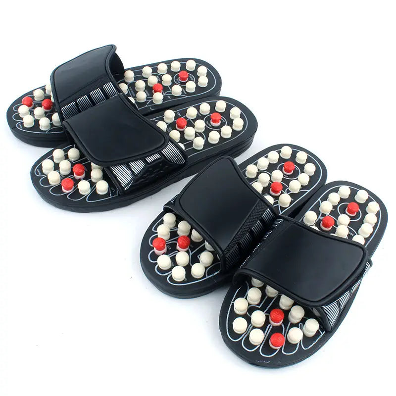black acupressure massage slippers for men and women featuring white and red spherical nodes on the soles for therapeutic foot stimulation