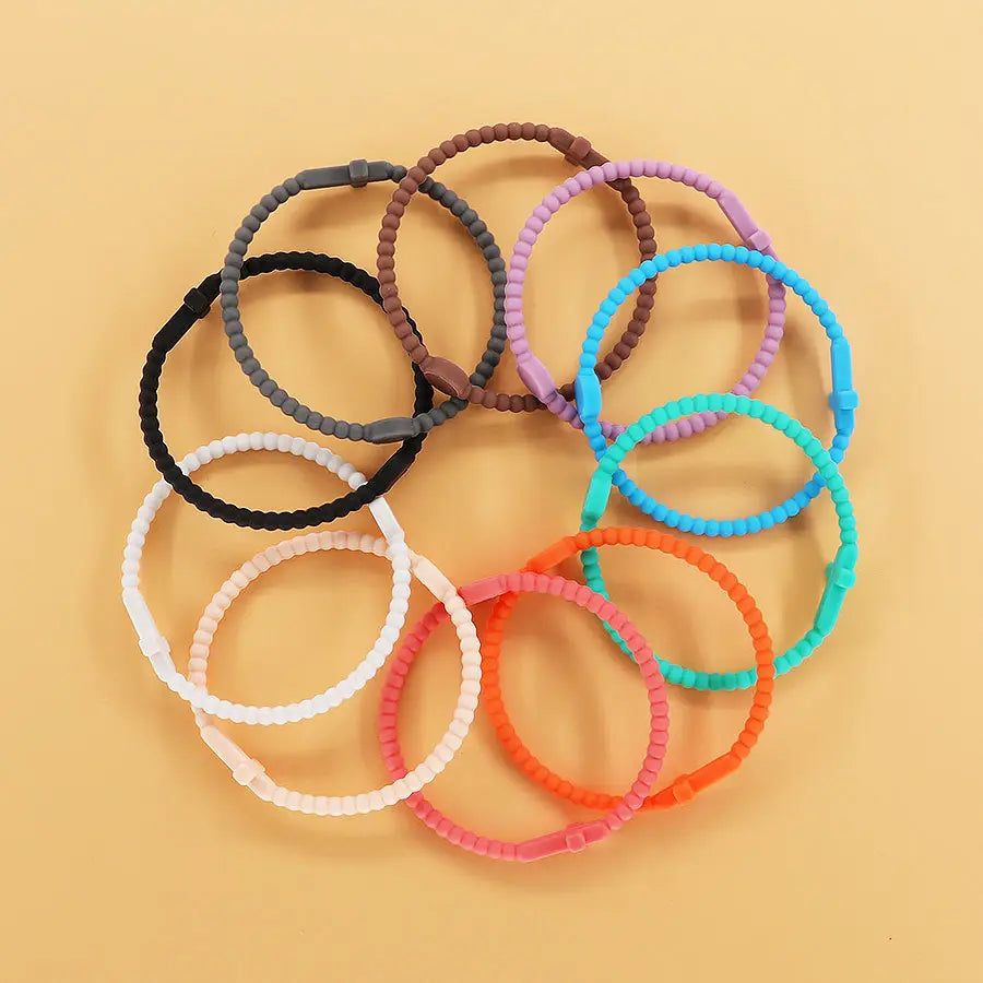 a collection of colorful beaded silicone cross bracelets with round clasps in assorted hues including black white gray brown pink orange teal and purple