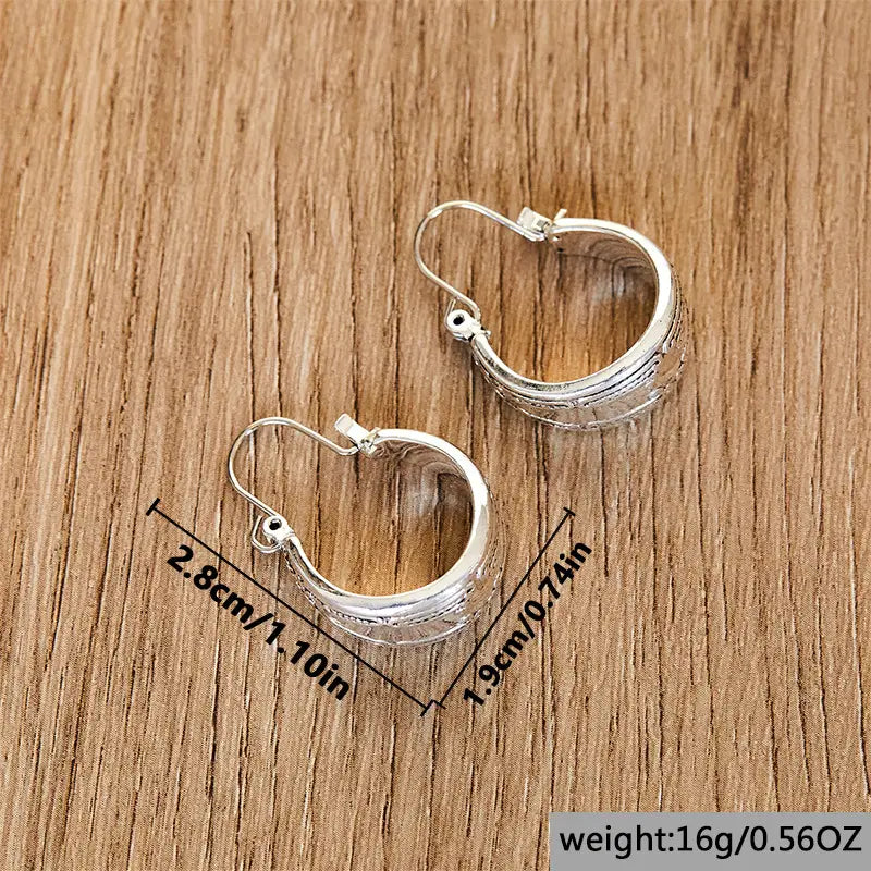 Boucles d’oreilles créoles vintage en alliage d’argent, présentant un motif côtelé texturé et une finition en argent poli.