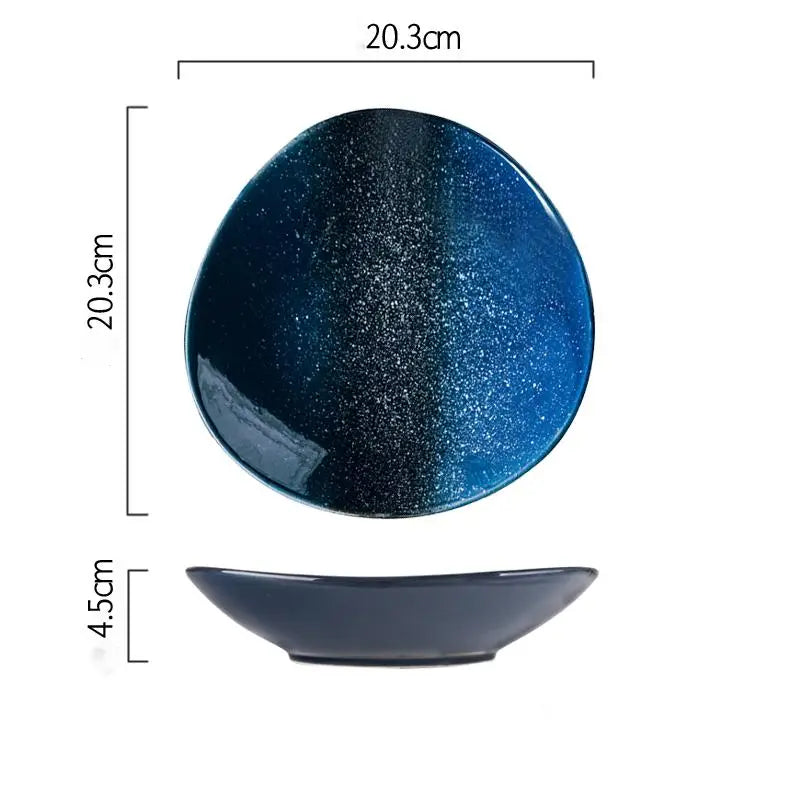 A glossy oval-shaped ceramic plate with a gradient blue finish transitioning from deep navy to vibrant sky blue, speckled with fine metallic glitter, named ceramic blue speckled Nordic round corner fillet plate.