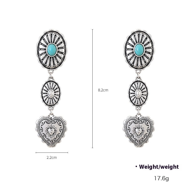 Silberfarbene Hängeohrringe mit türkisfarbenen Steinen, ovalen Anhängern mit klaren Kristallzentren und kunstvoll gestalteten herzförmigen Anhängern aus dem Schmuckset „Turquoise Heart and Sunburst Silver Jewelry Set“.