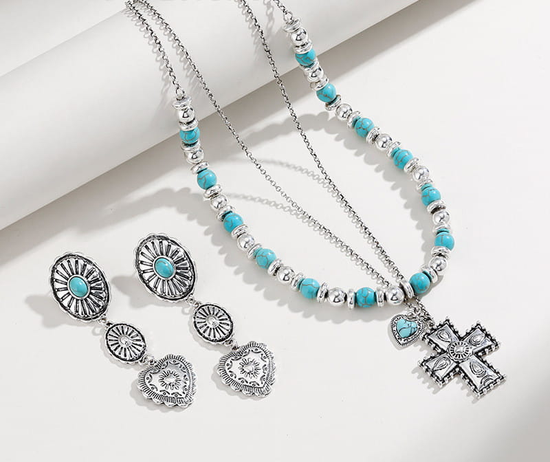 Silberfarbene Halskette mit türkisfarbenen Perlen und einem detaillierten Kreuzanhänger aus dem Schmuckset „Turquoise Heart and Sunburst Silver Jewelry Set“.