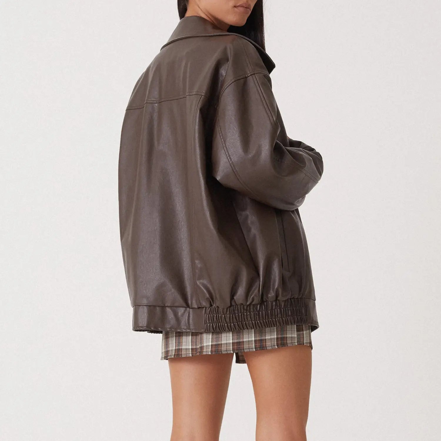 A sleek oversized brown faux leather bomber jacket for women with a relaxed fit and elasticated hem.