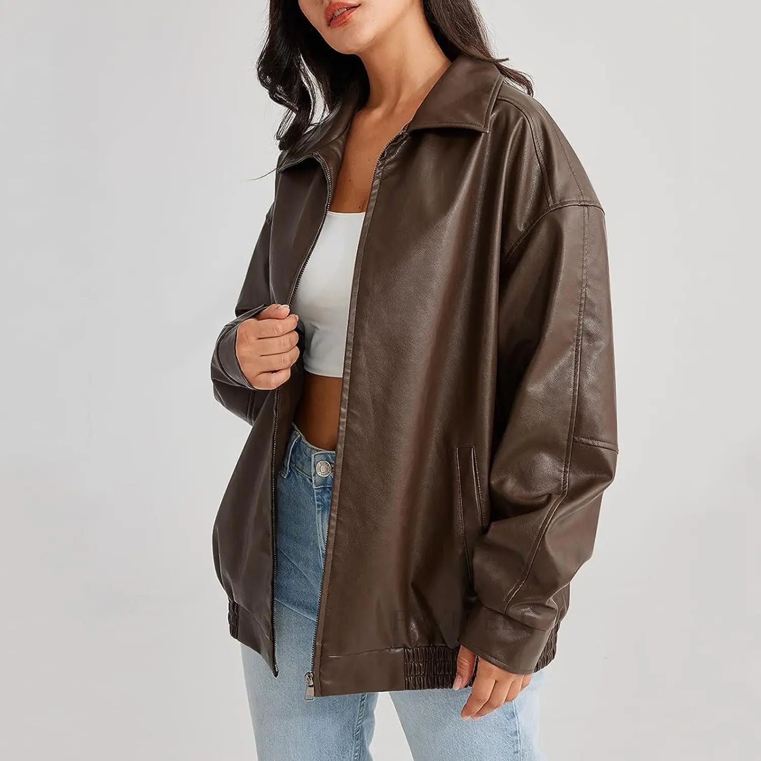 A brown faux leather bomber jacket with a classic collar and zipper front in a relaxed fit designed for women.