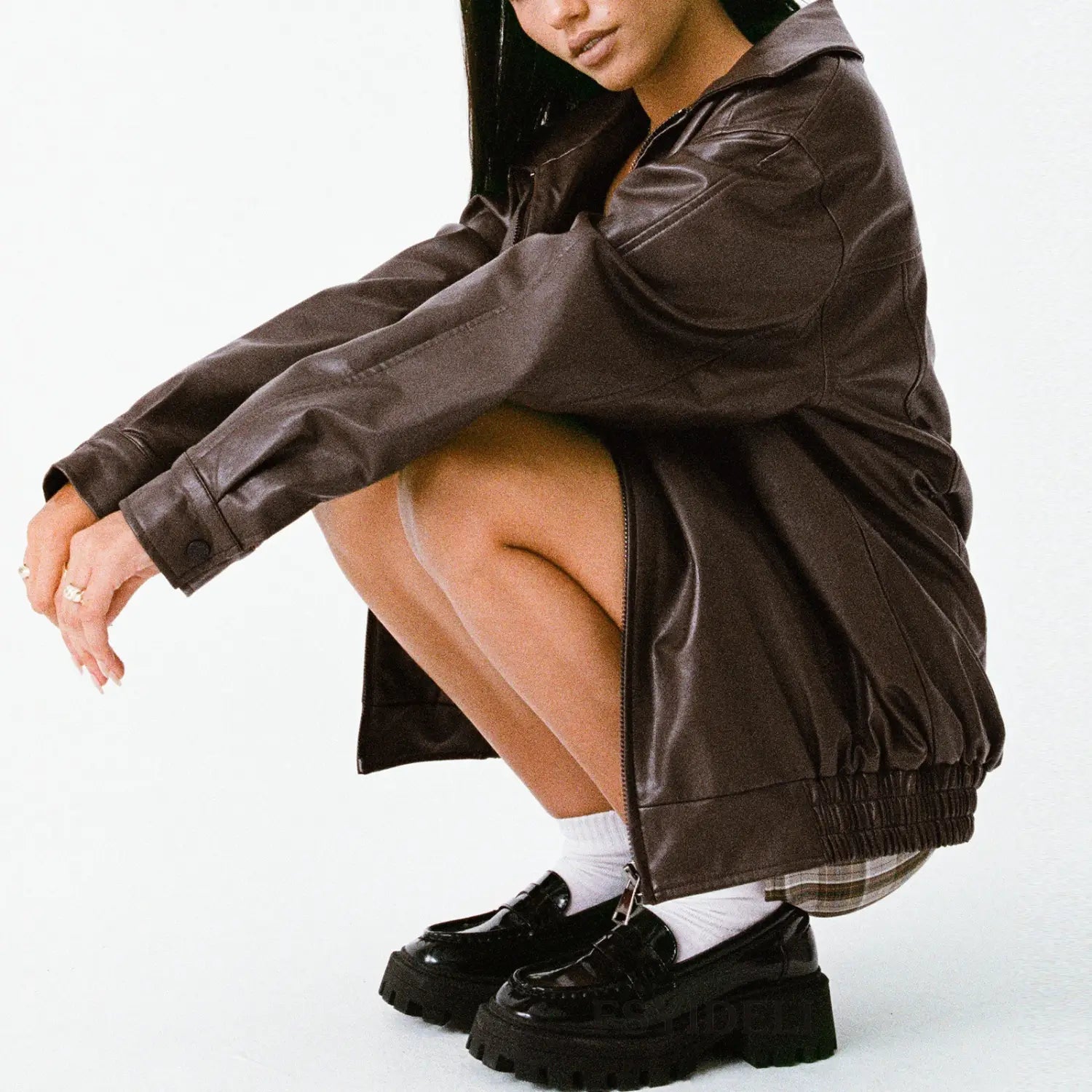 A dark brown faux leather bomber jacket with a relaxed fit and elasticated hem for women.