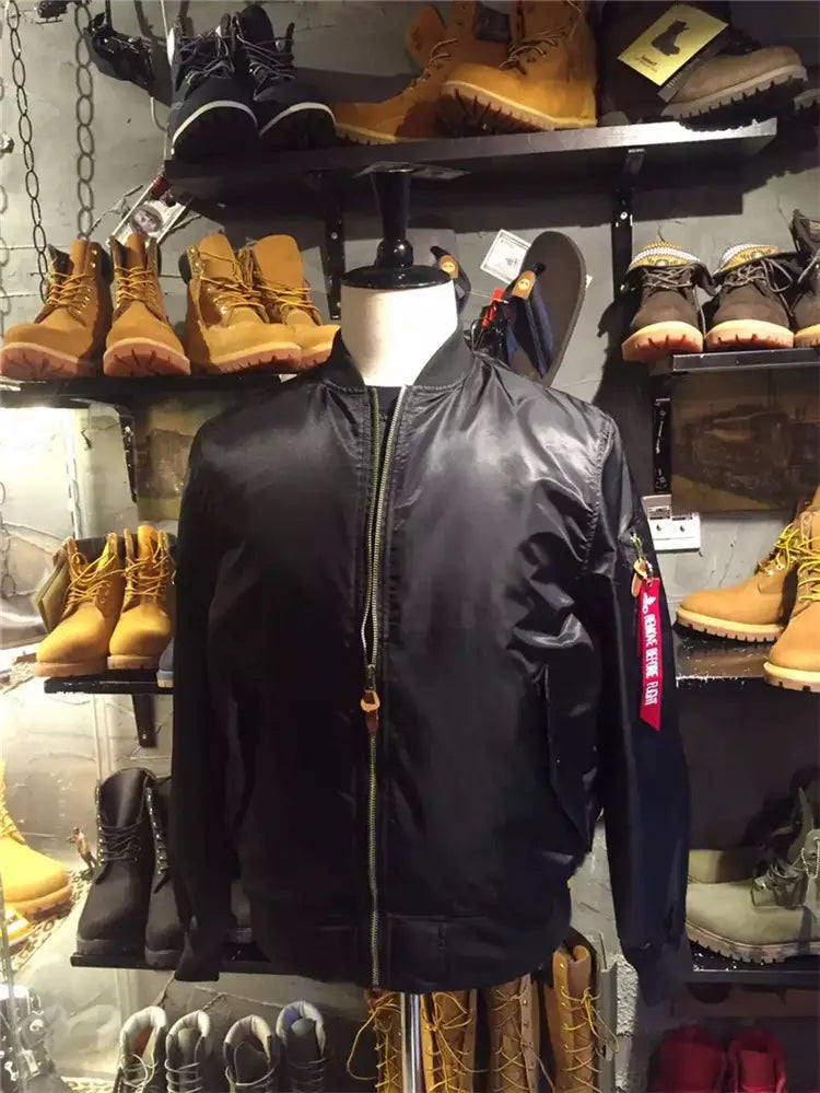 Black satin ma1 pilot bomber jacket with a stand collar and a red tag on the sleeve for casual wear.