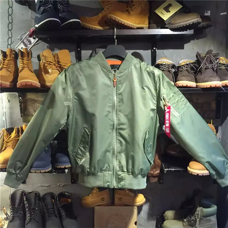 Olive green nylon ma1 pilot bomber jacket featuring a casual stand collar red zipper pull and an Alpha Industries patch on the left sleeve.