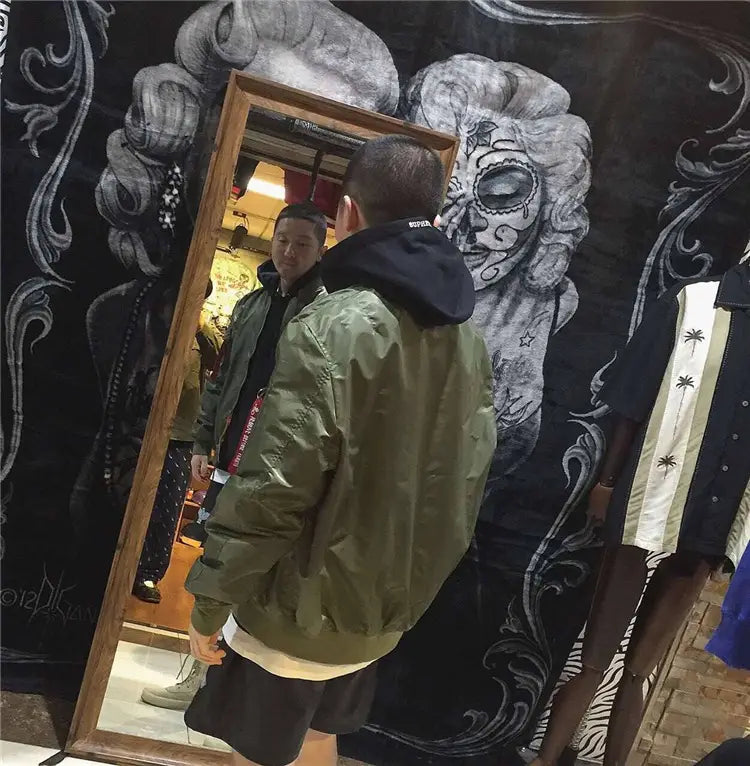 Olive green ma1 pilot bomber jacket with black hood and white trim at the hem designed for casual wear.