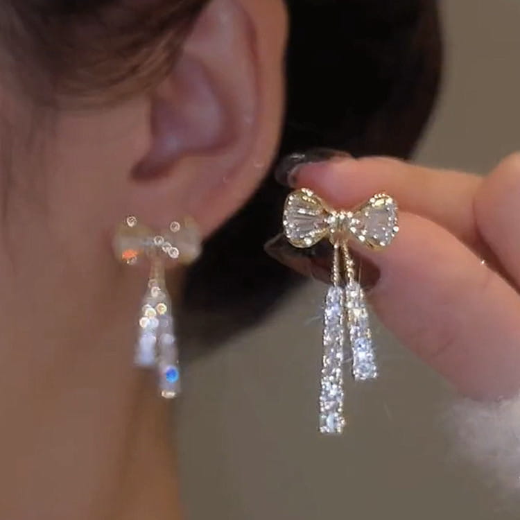 Delicate gold-toned bow earrings with sparkling crystals and dangling crystal strands in the crystal bow and pearl dangle earrings design.