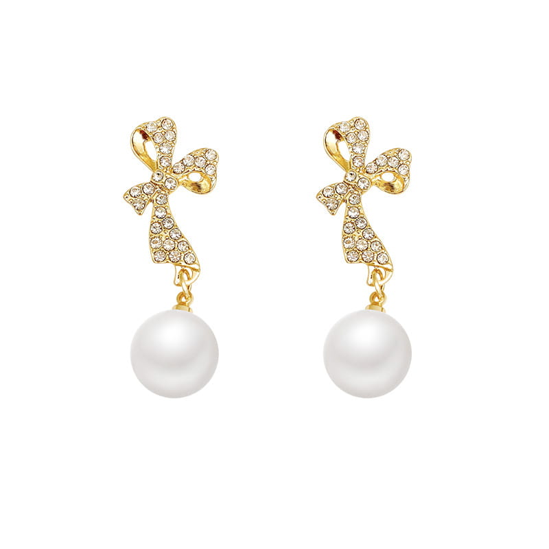 gold bow earrings featuring sparkling crystals and dangling white pearls in a crystal bow and pearl dangle earrings design