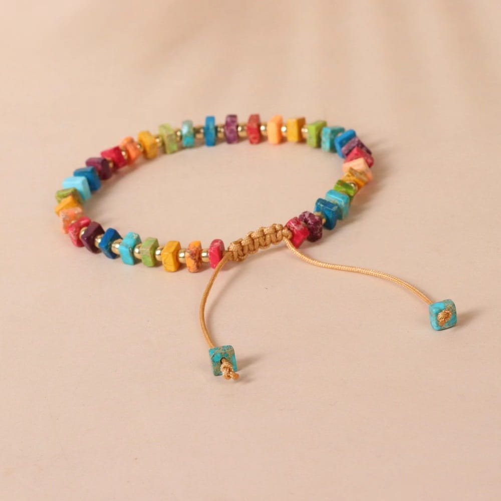Handcrafted rainbow square stone woven yoga bracelet featuring colorful turquoise and multi-hued stones on a tan adjustable cord.