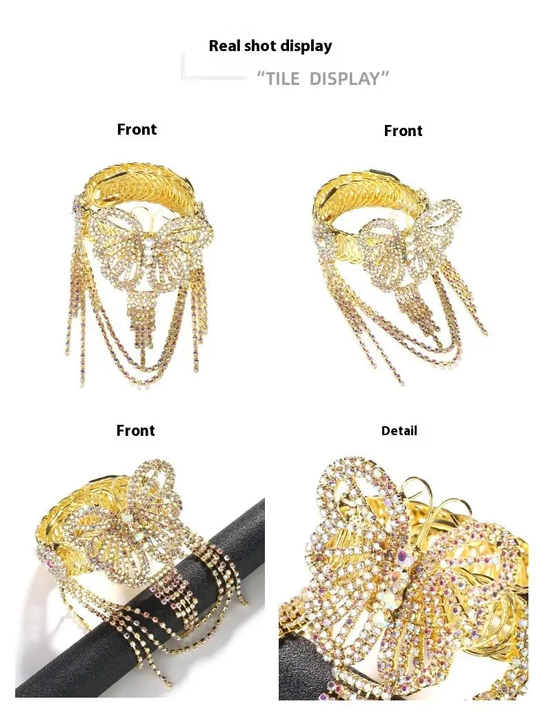 Gold-toned butterfly-themed bangle bracelet adorned with sparkling rhinestones and cascading tassel chains.