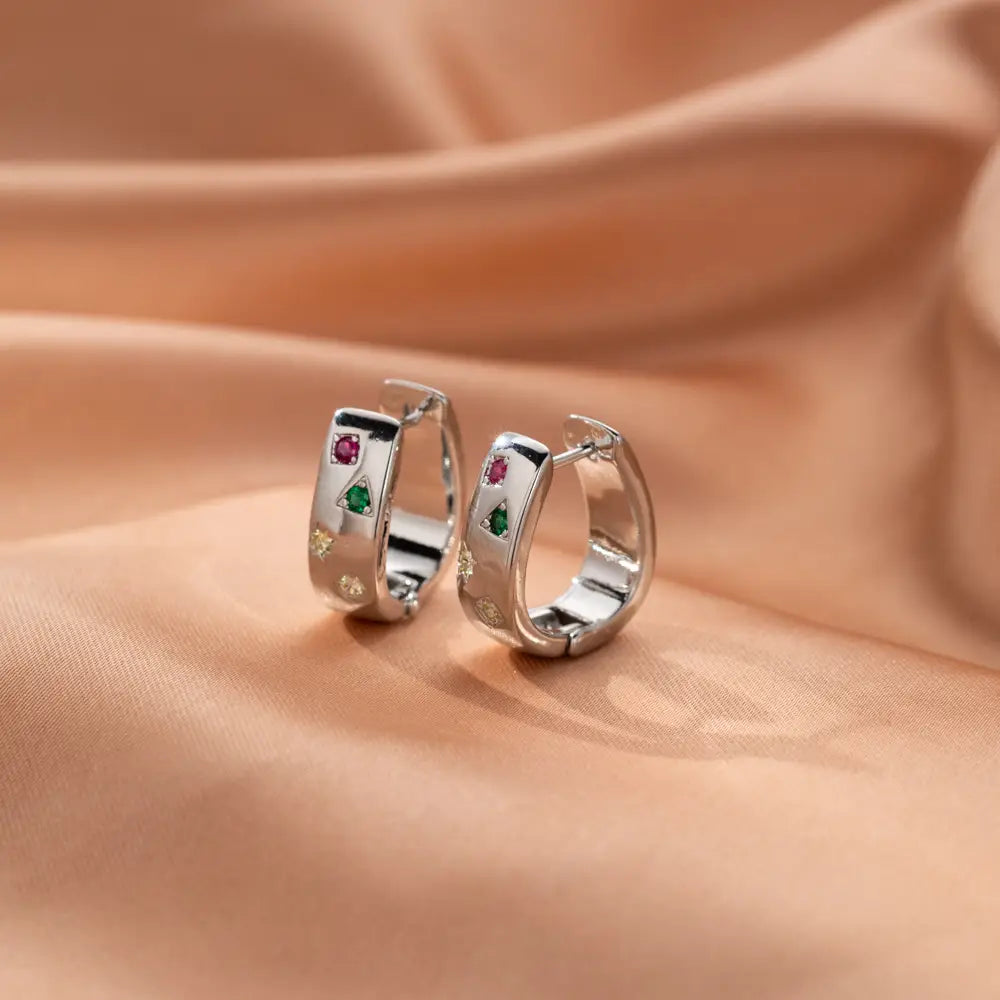 Silver geometric huggie hoop earrings adorned with pink and green zircon gemstones in a sleek modern design