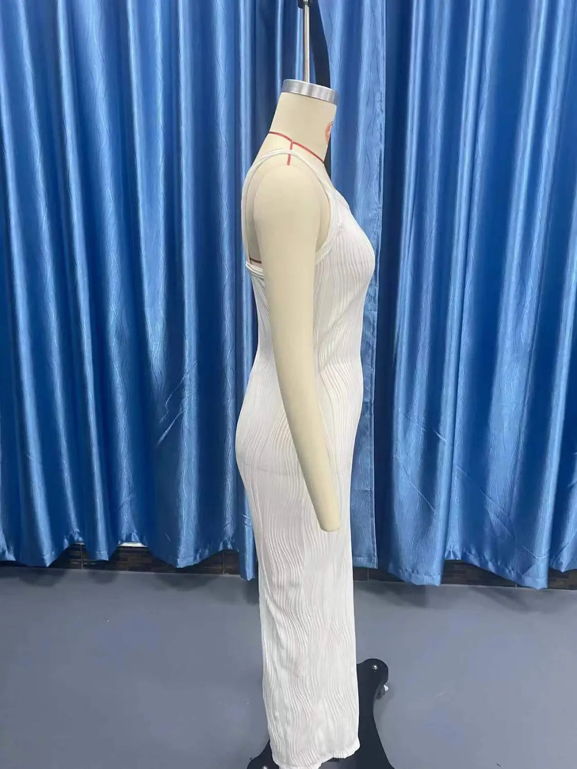 A white ribbed knit sleeveless midi dress with thin straps and a square neck displayed on a mannequin.