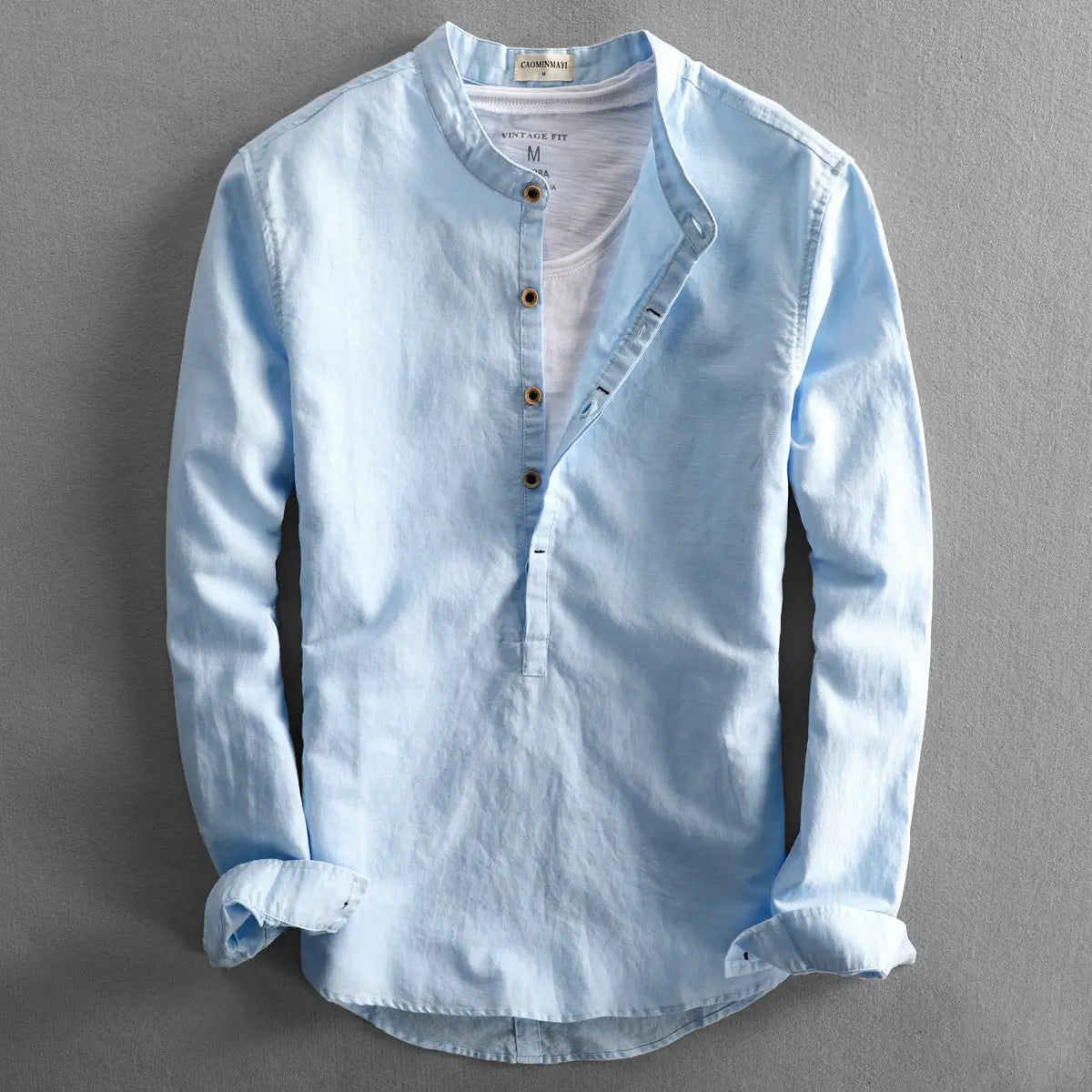 Light blue loose linen men’s long sleeve shirt with mandarin collar and wooden buttons.