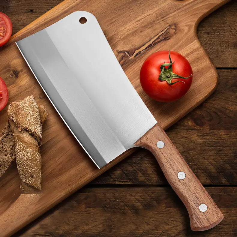Une hache/couteau de chef en acier inoxydable avec une lame polie et réfléchissante et un manche en bois robuste fixé par trois rivets en argent.