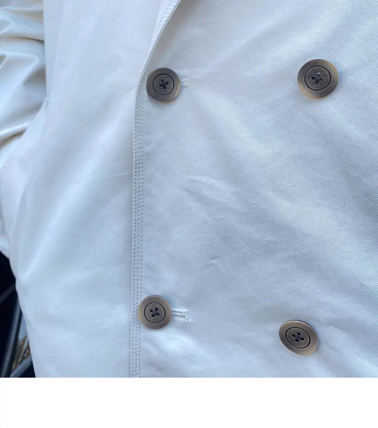 White double breasted trench coat for men featuring four round metallic buttons with cross design on a double breasted jacket front.