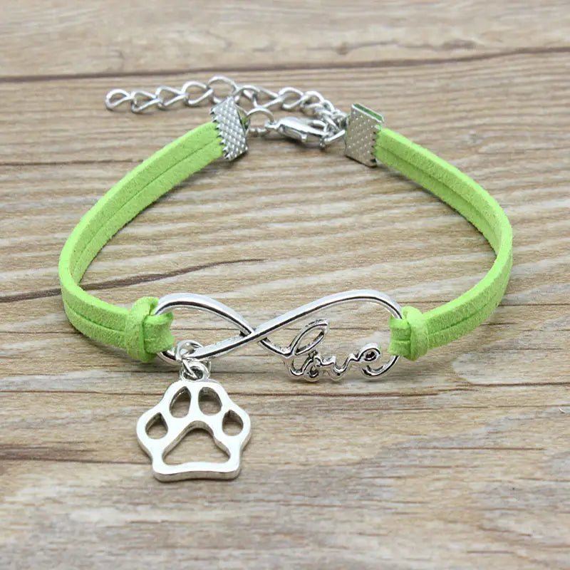 Lime green hand-woven suede bracelet featuring a silver infinity charm engraved with love and a paw print pendant for pet lovers.