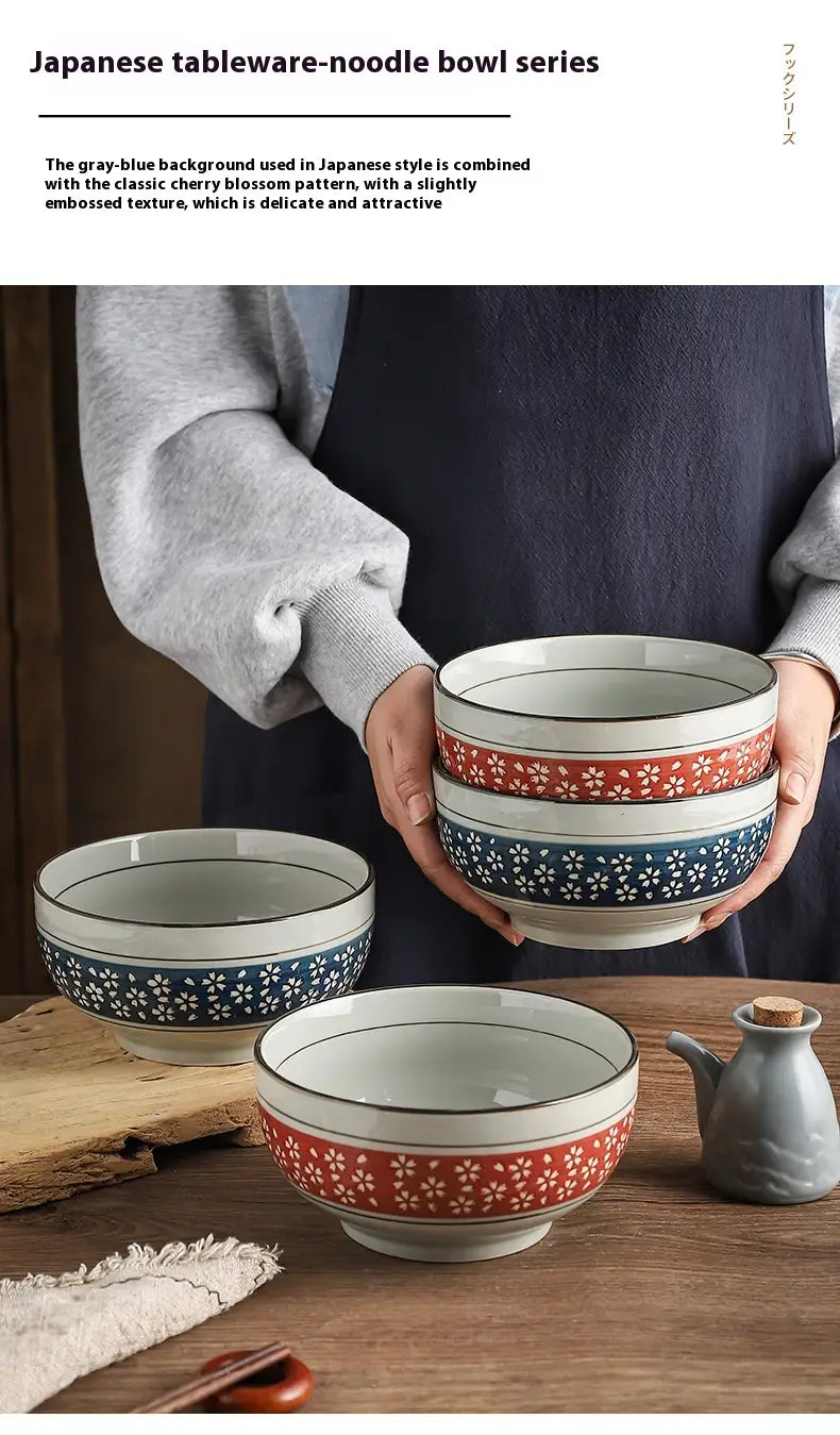 Set of japanese-style ceramic noodle bowls featuring delicate red and blue cherry blossom patterns on a gray-blue embossed background for serving soup.
