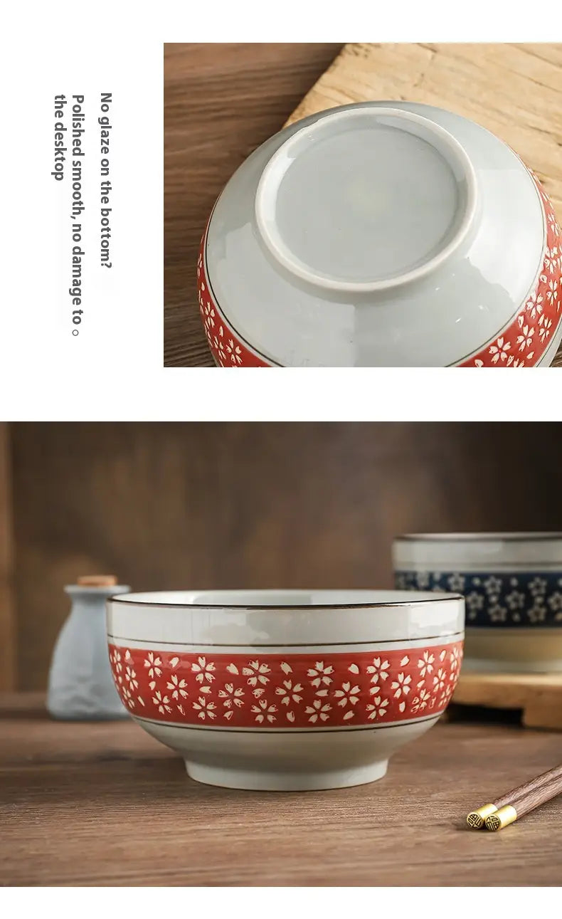 A white ceramic 7 inch noodle bowl with a vibrant red band and delicate white cherry blossom patterns around its midsection designed for soup.
