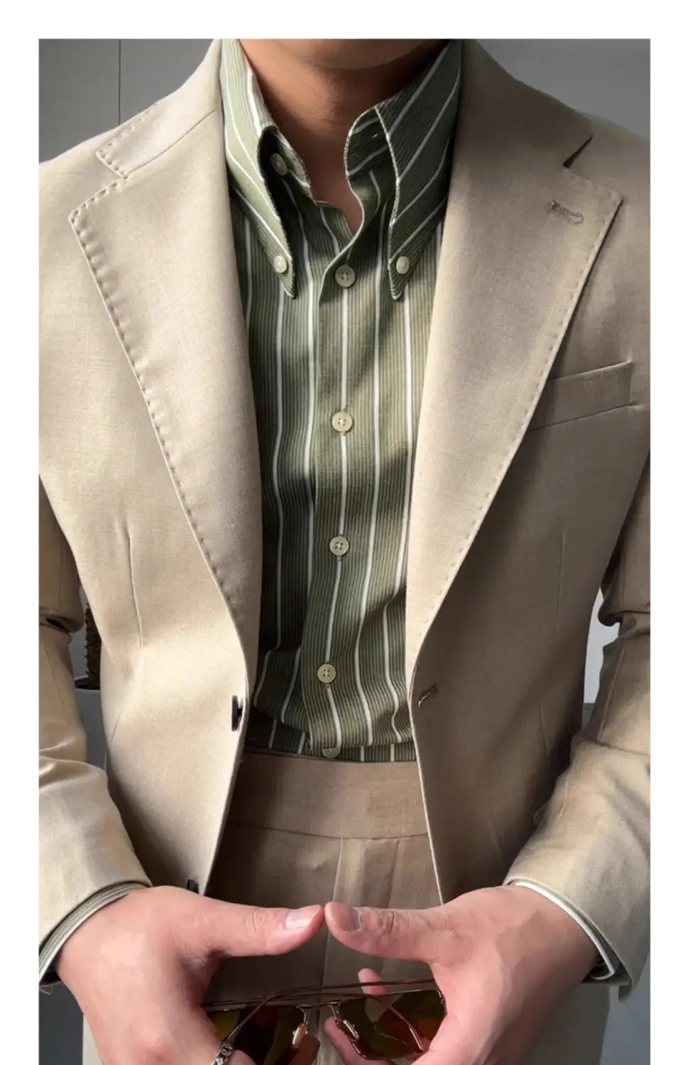 Beige Woll-Sakko mit dezenter Kappnaht und klarer Passform, kombiniert mit einem Herren-Slim-Fit-Hemd mit vertikalen Streifen und langem Ärmel im Business-Stil.