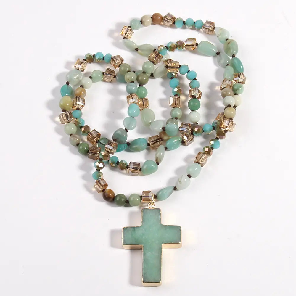 A turquoise and gold-toned bohemian natural stone and glass beaded necklace with a matching cross pendant.